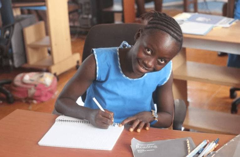Give a notebook to a little girl in Sierra Leone
